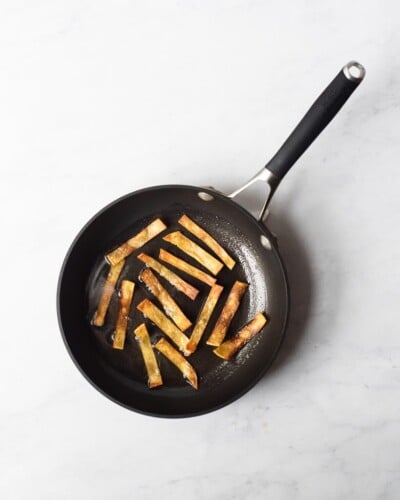 corn tortilla strips being fried in a pan