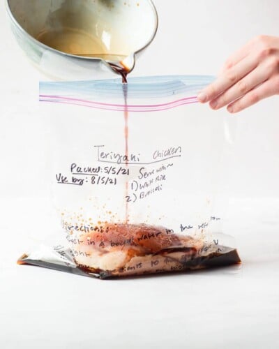freezer meal teriyaki chicken in a labeled ziplock bag on a marble surface