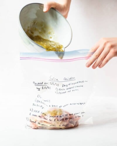 freezer meal salsa chicken in a labeled ziplock bag on a marble surface
