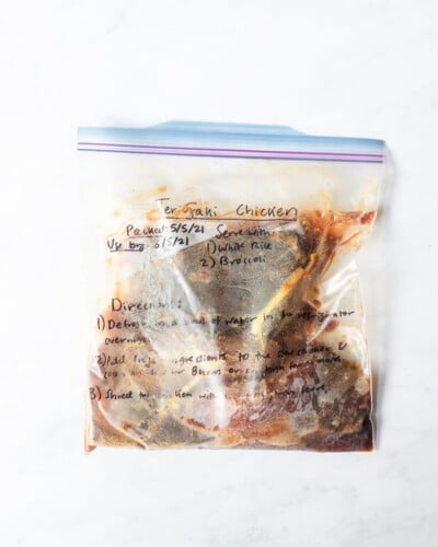 freezer meal teriyaki chicken in a labeled ziplock bag on a marble surface
