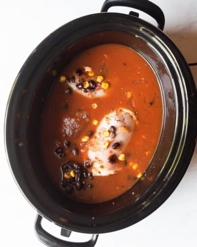 a raw, thawed freezer meal in a slow cooker sitting on a marble surface