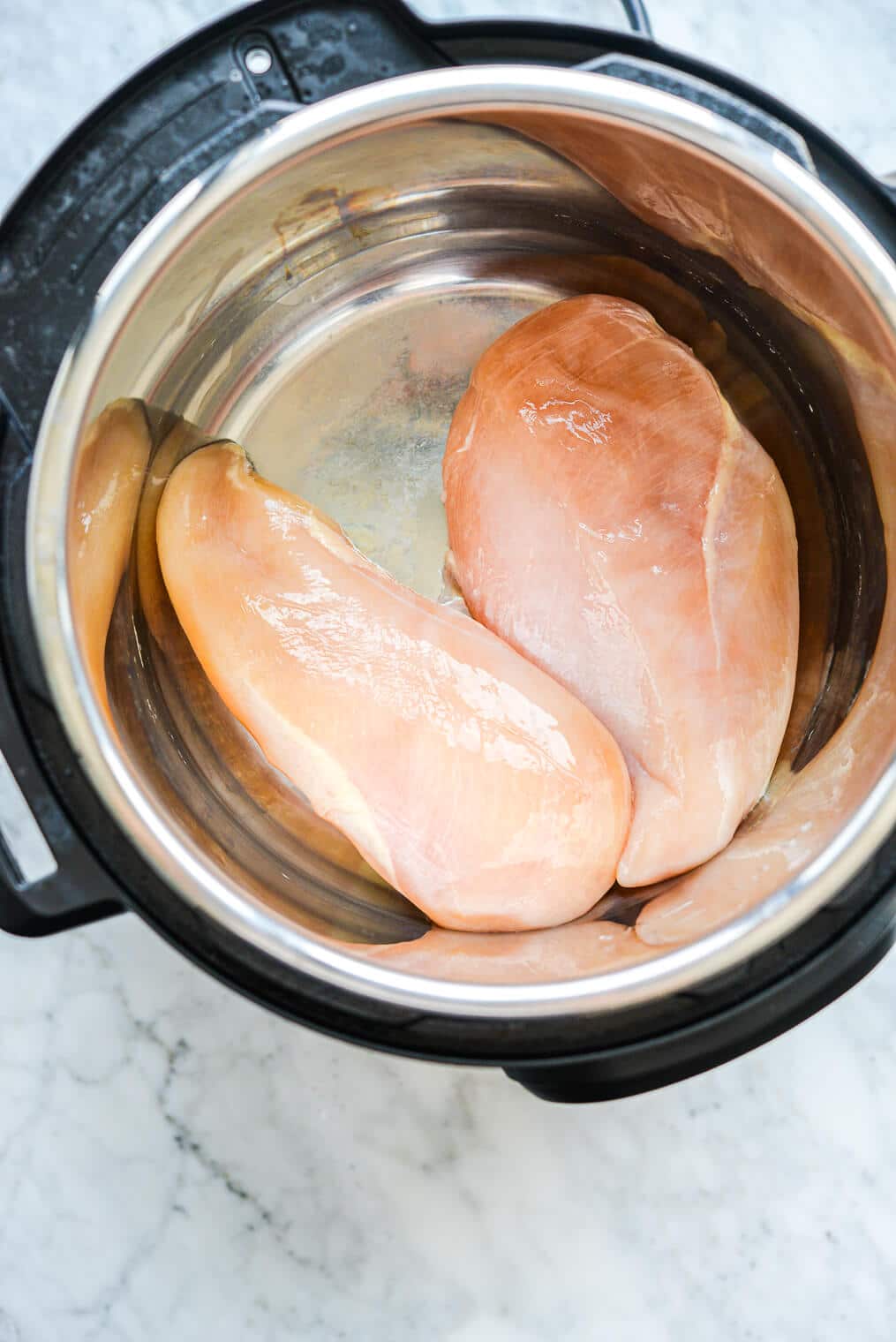 two raw chicken breasts in an instant pot