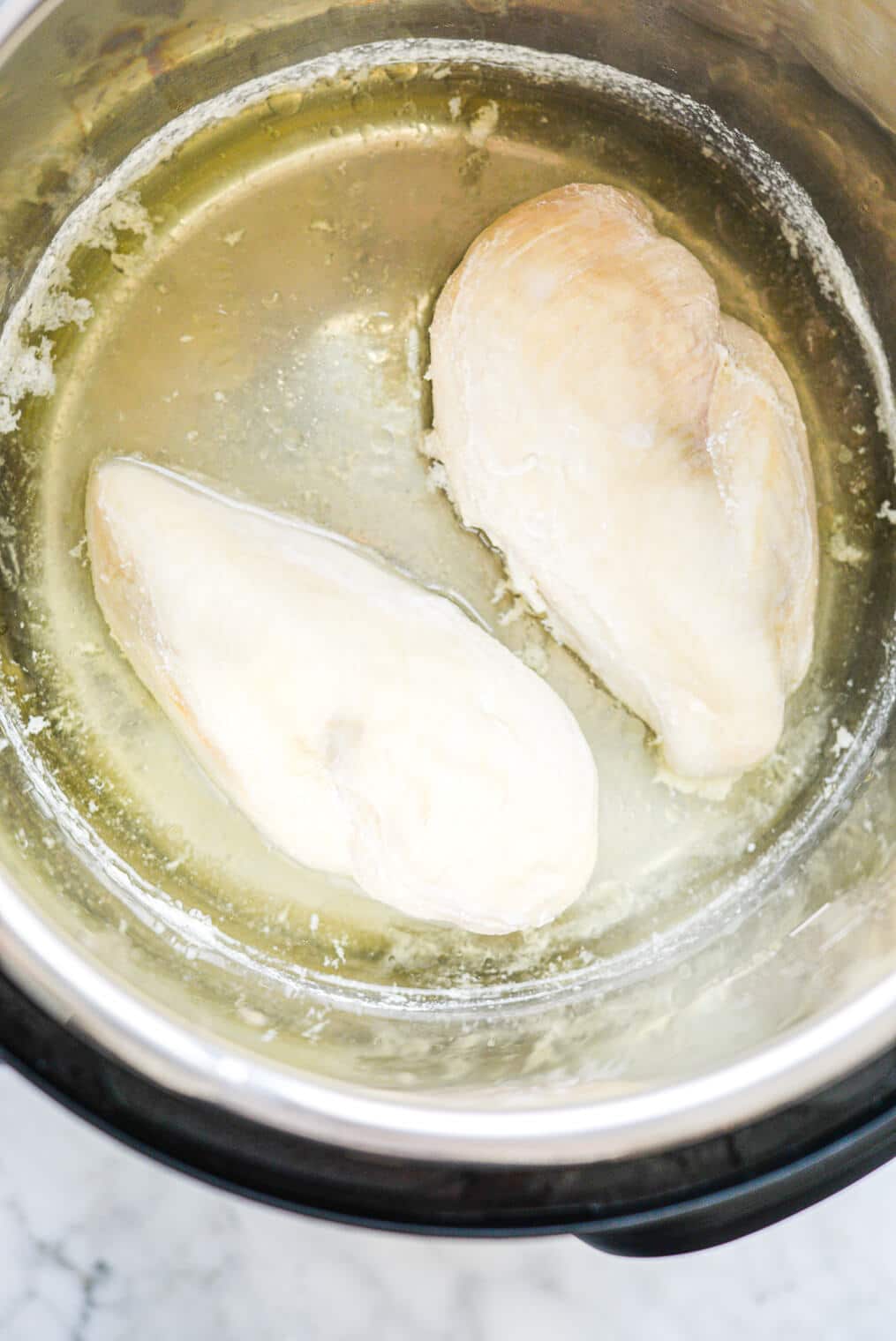 two cooked chicken breasts in an instant pot