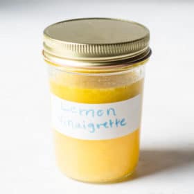 a small mason jar filled with a yellow liquid labeled "lemon vinaigrette"