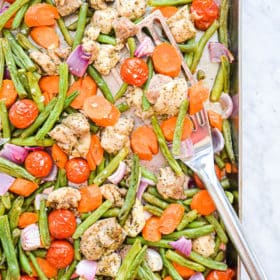 a sheet pan chicken thighs and veggies dinner -- green beans, carrots, onions, tomatoes, and chicken thighs