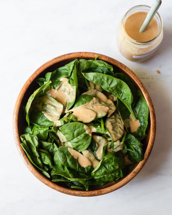 spinach leaves drizzled with homemade peanut dressing