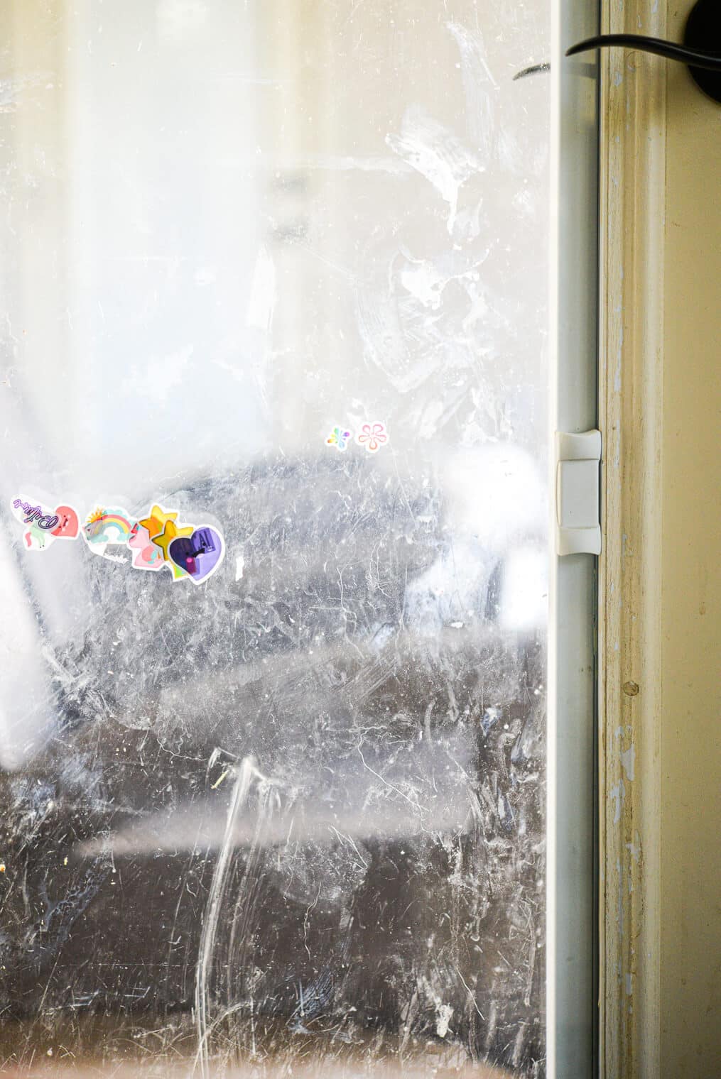 a glass door with stickers and smudges on it