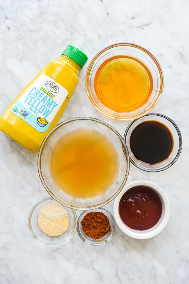 all of the ingredients for a carolina bbq sauce in different sized bowls on a marble surface