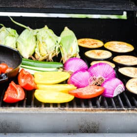 an assortment of veggies being grilled on a gas grill