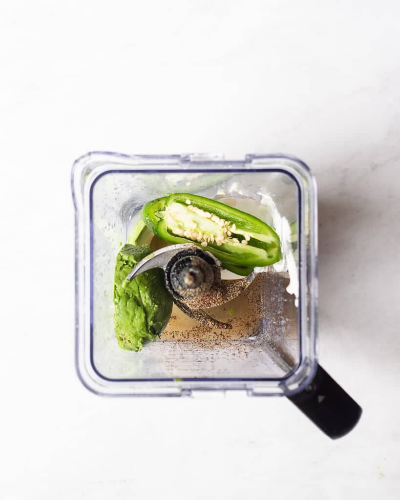 all of the ingredients for a avocado dressing in a blender before being blended