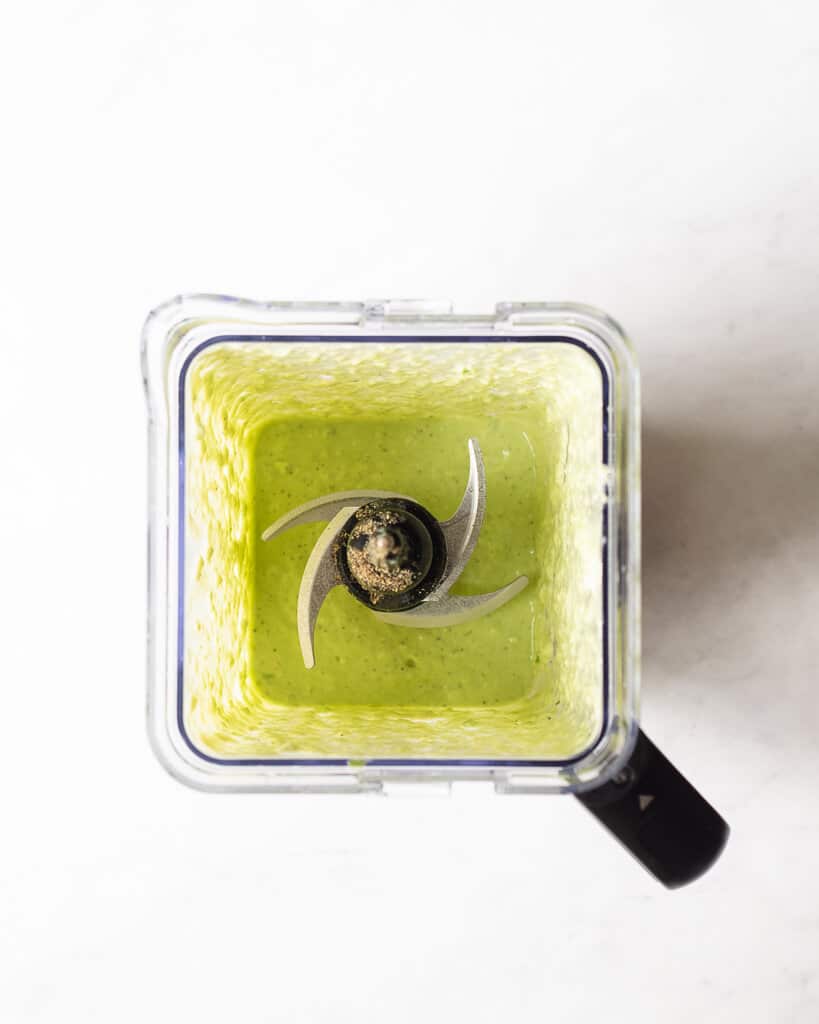 a blender of avocado dressing already blended and in a blender