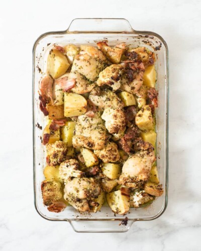 a casserole dish of chicken thigh pesto bake that just came out of the oven and is done baking