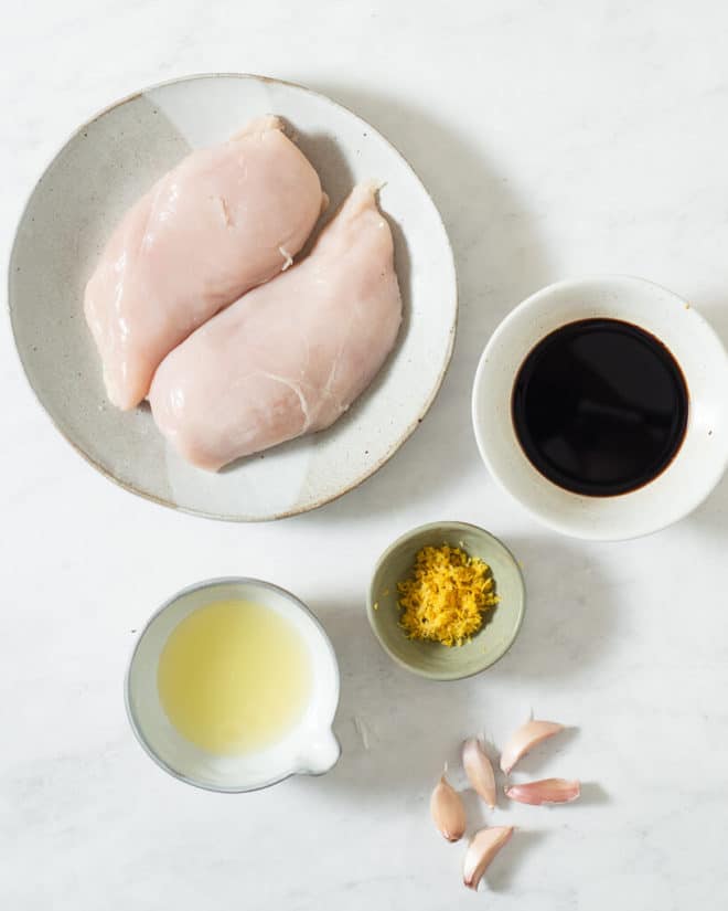 all of the ingredients for a grilled chicken marinade in different sized bowls on a marble surface