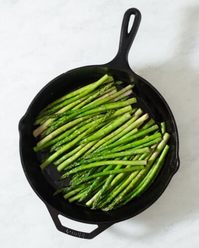a bunch of asparagus in a cast iron skillet