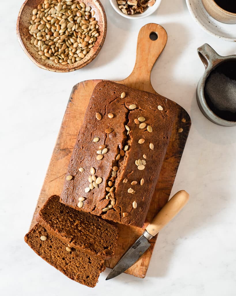a loaf of healthy pumpkin bread on a cutting board next to a knife