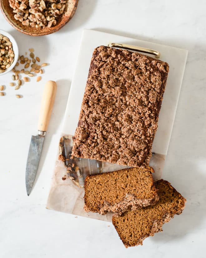 a loaf of keto pumpkin bread on a cutting board next to a knife