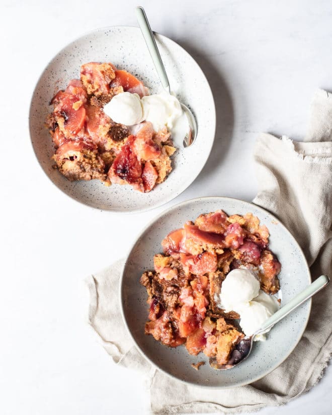 2 servings of peach dump cake with two small scoops of vanilla ice cream