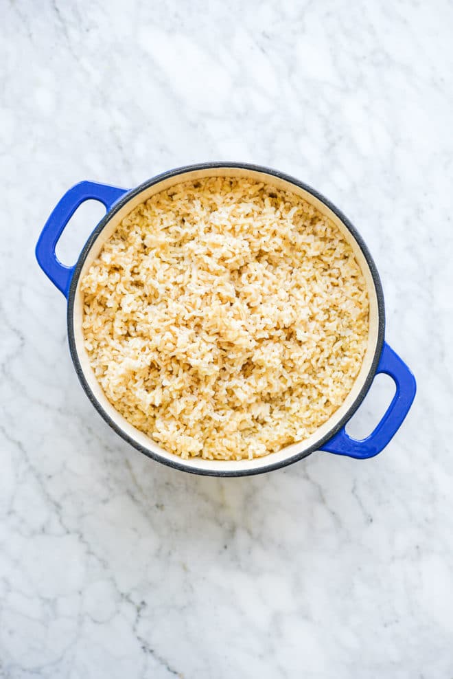 an enameled cast iron pot filled with fluffy brown rice