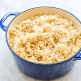 an enameled cast iron pot filled with fluffy brown rice