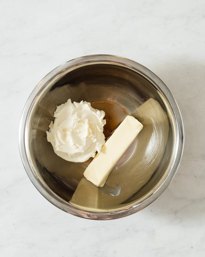 cream cheese, butter, and vanilla in a large metal bowl before mixing together