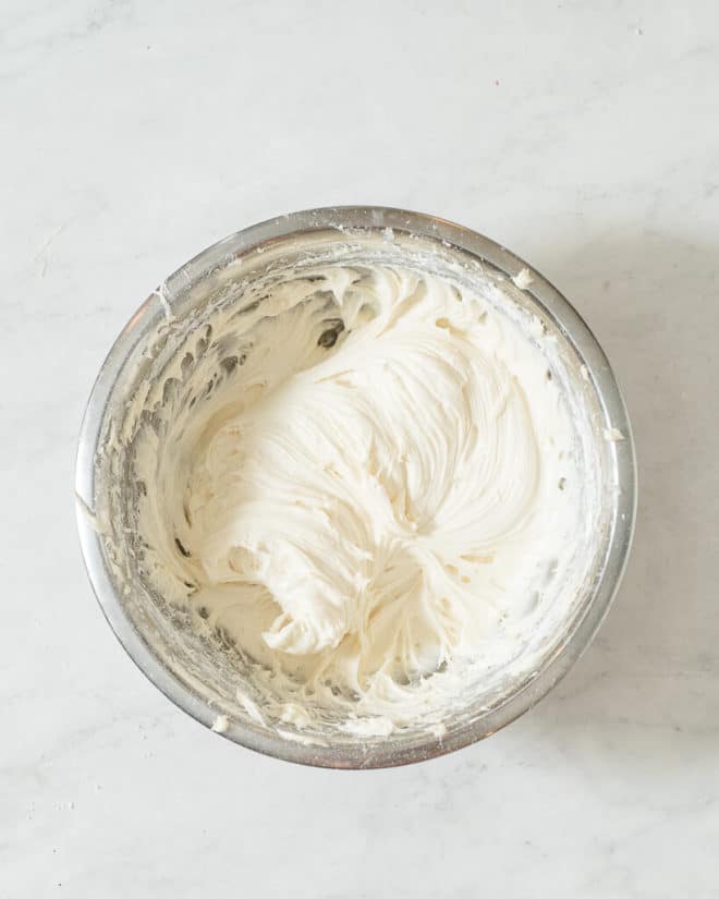 a large metal bowl of cream cheese frosting