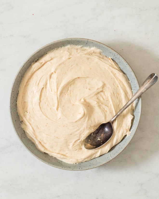 a bowl of peanut butter cream cheese frosting in a bowl