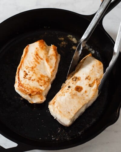 chicken breasts searing in a skillet