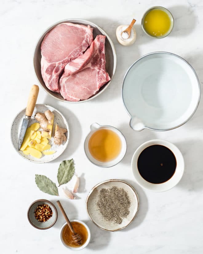 all of the ingredients for a pork chop brine in different sized bowls on a marble surface