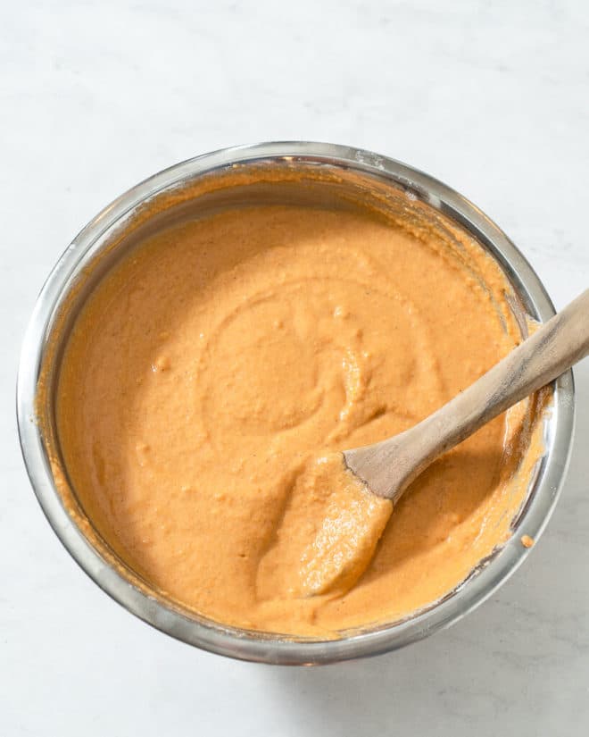 a metal mixing bowl of pumpkin pancake batter