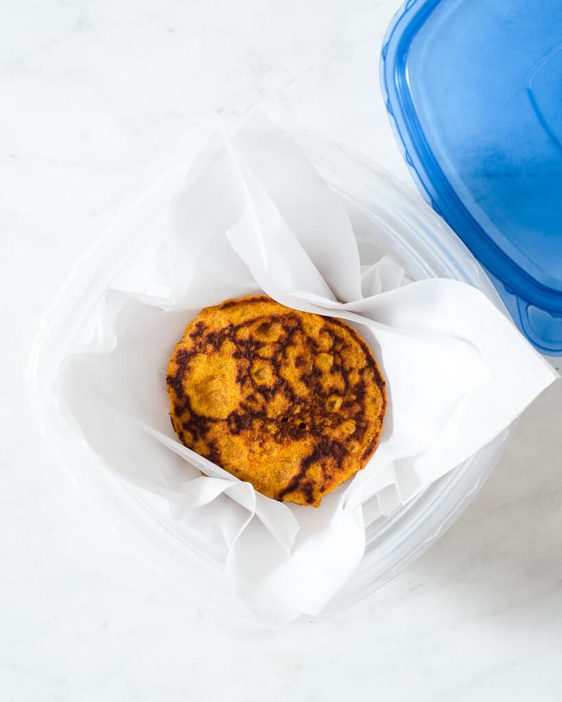 pumpkin pancakes in a tupperware container to freeze