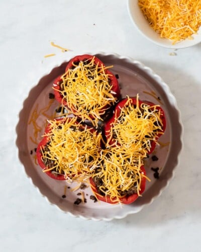 a baking dish of 4 tex mex stuffed peppers before being baked in the oven