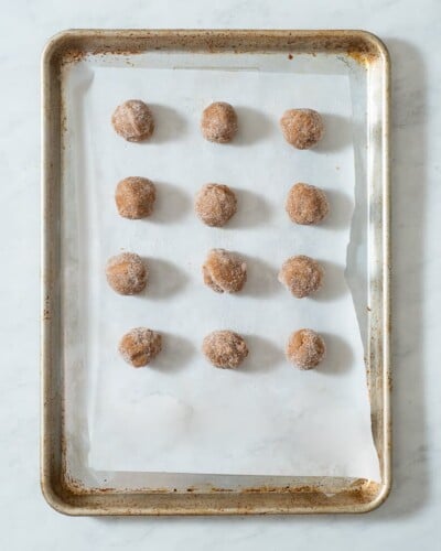 a parchment paper lined cookie sheet of peanut butter cookies