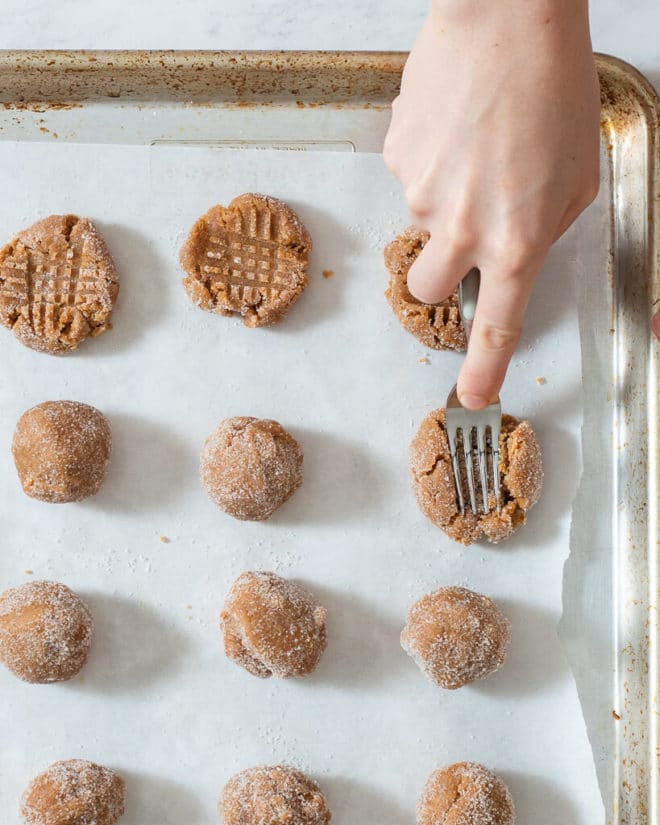 a parchment paper lined cookie sheet of peanut butter cookies