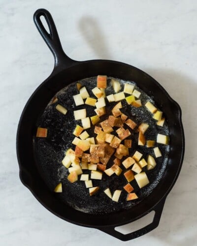 a cast iron skillet with cubed cinnamon apples