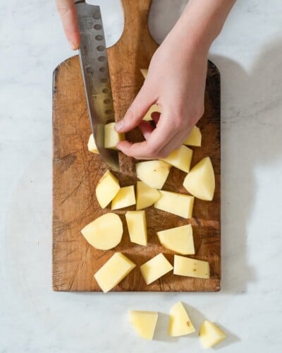 a person chopped potatoes on a cutting board