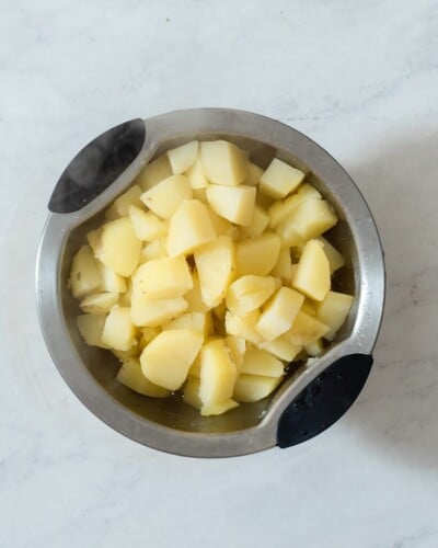 a bowl of softened chunks of potatoes