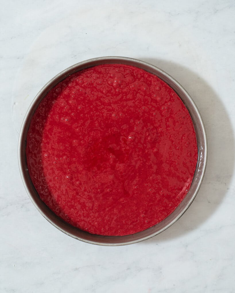 a circular pan of red velvet cake batter