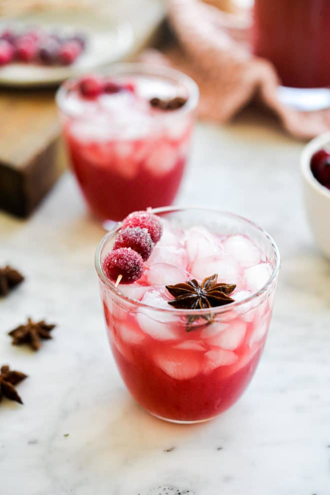 a cranberry margarita sitting in front of another cranberry margarita