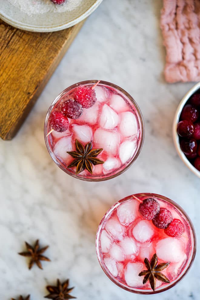 a top down photo of two cranberry margaritas garnished with star anise and sugared cranberries