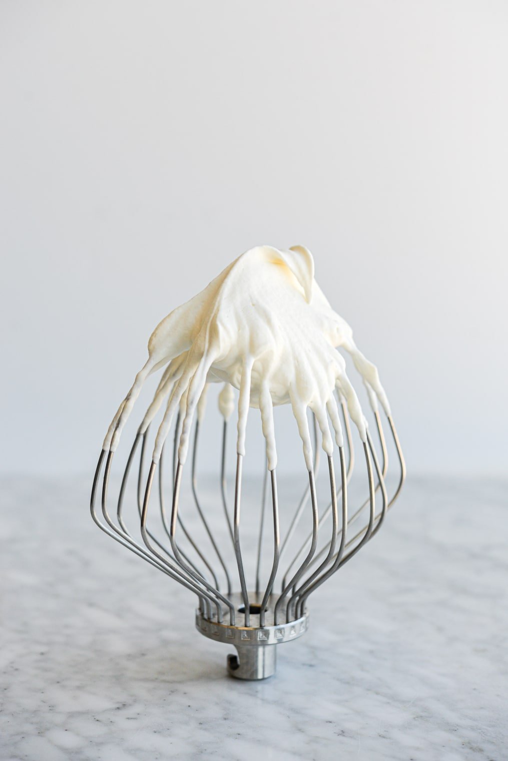 a mixer whisk with whipped cream on it