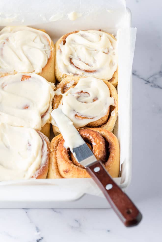 cinnamon rolls that have been iced in a baking dish