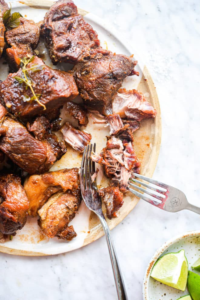 authentic carnitas being shredded with two forks