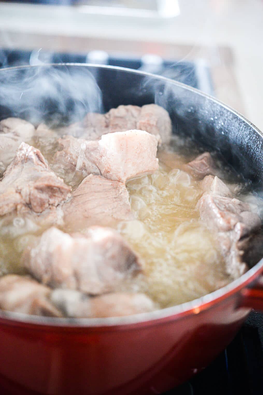 authentic carnitas pieces boiling in a pot of hot lard
