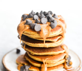a stack of protein pancakes topped with peanut butter and chocolate chips