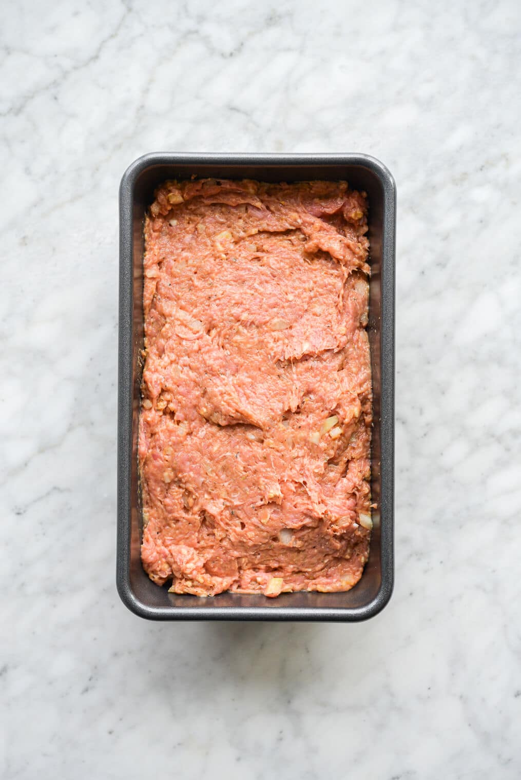 raw turkey meatloaf in a loaf pan before going into the oven