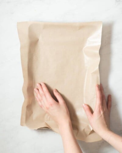 a person lining a baking sheet with parchment paper