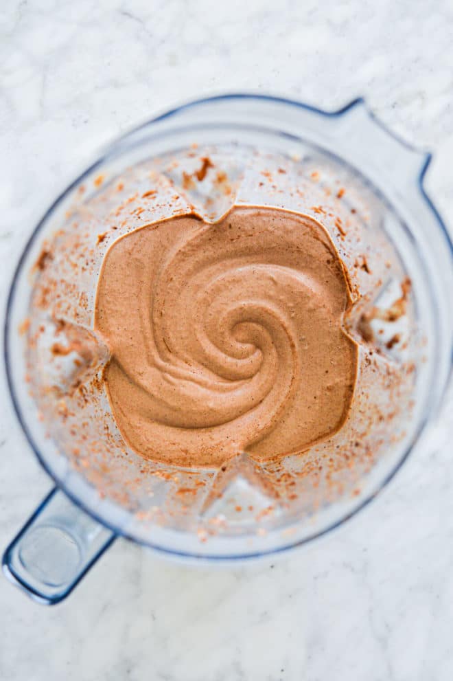 Top down view of blender with chocolate smoothie ingredients blended