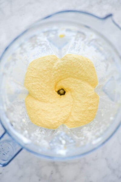 Top down view of blender with mango smoothie ingredients blended