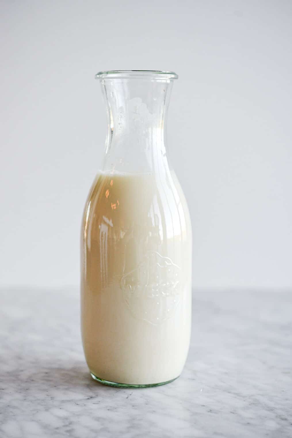 Glass milk jar filled with oat milk.