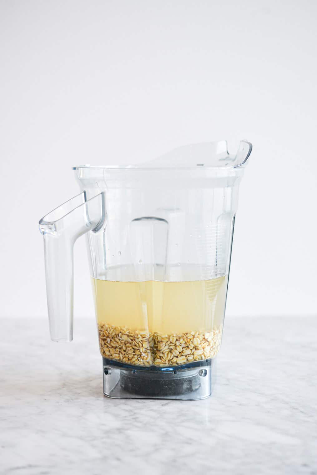 Blender filled with oats and topped with water.